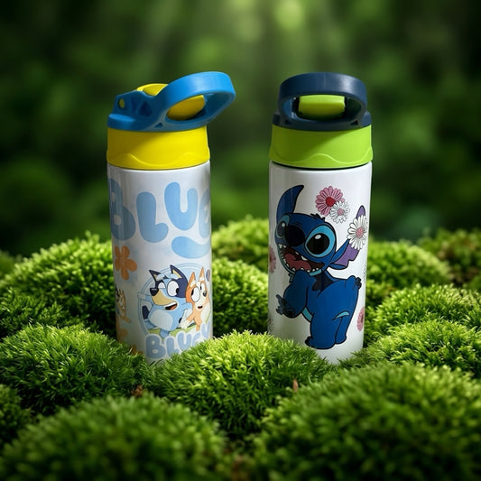 Two custom toddler sippy cups, one with Stitch and the other with Bluey designs, placed outdoors on green grass